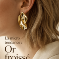 Femme portant des bijoux dorés froissés pour un look élégant et moderne.