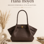 Sac tote moyen Hana en brun foncé posé sur une table avec des accessoires de mode.