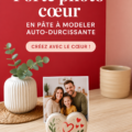 Un porte-photo cœur fait main en pâte à modeler sur une table avec une photo insérée.
