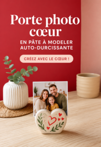 Un porte-photo cœur fait main en pâte à modeler sur une table avec une photo insérée.