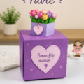 Photo d'une mère heureuse recevant un cadeau fait main de sa fille.